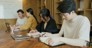 Students studying together in a classroom and taking notes. This is an ideal representation of students of the Overseas Koreans Scholarship in South Korea.